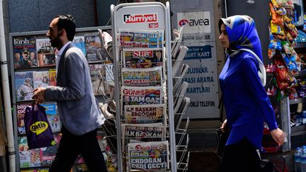 Des passants devant un kiosque à journaux à Istanbul (Turquie) (Photo d'illustration). (YASIN AKGUL / AFP)