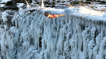 Plongeon dans le lac Jingpo depuis les chutes d'eaux glac&eacute;es de Mudanjiang (Chine), le 18 d&eacute;cembre 2011. (AFP)