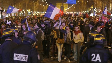 Des militants face aux forces de police, sur l'avenue des Champs-Elys&eacute;es, le 24 mars 2013, au terme de la "Manif pour tous".&nbsp; (PIERRE VERDY / AFP)