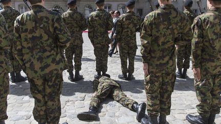 Un soldat g&icirc;t sur le sol au passage de Fran&ccedil;ois Hollande, &agrave; Berne (Suisse), le 15 avril 2015. (PETER KLAUNZER / AP / SIPA)