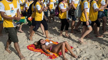 De jeunes p&egrave;lerins marchent sur la plage d'Ipanema &agrave; Rio de Janeiro (Br&eacute;sil) o&ugrave; le pape Fran&ccedil;ois est attendu pour les Journ&eacute;es Mondiales de la Jeunesse, le 21 juillet 2013. (YASUYOSHI CHIBA / AFP)