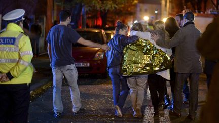 Des jeunes gens sortent de la discoth&egrave;que o&ugrave; une explosion a tu&eacute; au moins 27 personnes, &agrave; Bucarest (Roumanie), le 31 octobre 2015. (REUTERS)