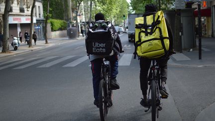 Deux livreurs à vélo dans les rues de Paris, pendant l'épidémie de coronavirus, le 3 mai 2020. (VICTOR VASSEUR / RADIOFRANCE)