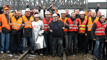 Des salari&eacute;s d'ArcelorMittal Florange sur la ligne ferroviaire France-Luxembourg, &agrave;&nbsp;Ebange (Moselle), vendredi 2 mars 2012 (PATRICK HERTZOG / AFP)