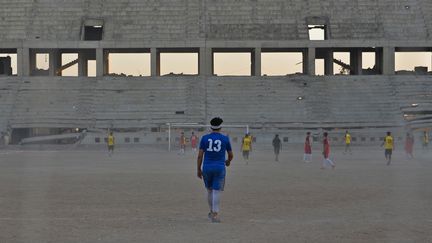 Les joueurs du FC Al-Mossoul s'entraînent dans le stade Al-Idara al-Mahalia, qui a été ravagé et qui servait autrefois de dépôt d'armes aux combattants du groupe d'État islamique, près de la ville de Mossoul, dans le nord de l'Irak, le 22 octobre 2020.  (ZAID AL-OBEIDI / AFP)