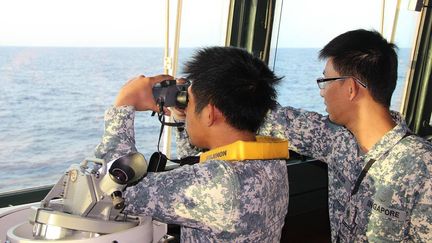 Des marins singapouriens scrutent l'horizon &agrave; la recherche du vol MH370 au large de Singapour en mer de Chine m&eacute;ridionale, le 13 mas 2014. (SINGAPORE NAVY / AFP)