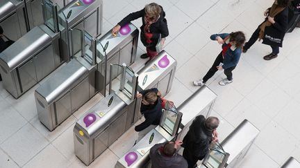 Des passagers valident leurs passes Navigo, le 23 mars 2016, à l'entrée du métro de la gare du Nord, à Paris. (MAXPPP)