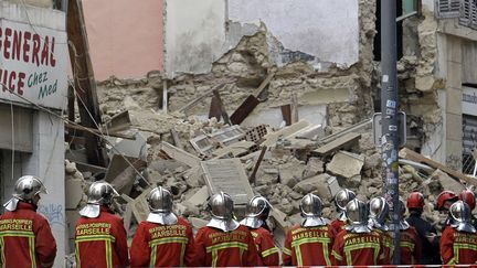 Des pompiers arrivent&nbsp;au 63 et 65 rue d'Aubagne, à Marseille (Bouches-du-Rhône), où deux immeubles vétustes se sont effondrés, tuant huit personnes.&nbsp;Les&nbsp;services de la ville et de la métropole, qui avaient été alertés des risques concernant l'état des logements dans le quartier populaire de Noailles, ont été pointé du doigt par les habitants. (CLAUDE PARIS / AP / SIPA)