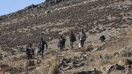 Des Syriens et des Libanais vivant au Liban passent du côté syrien avec ce qu'ils ont pu emporter après les attaques israéliennes à Massna, au Liban, le 4 octobre 2024. (MURAT SENGUL / ANADOLU / VIA AFP)