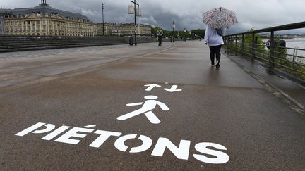 Des&nbsp;piétons marchent&nbsp;sur les bords de la Garonne au premier jour du déconfinement, lundi 11 mai, à Bordeaux.&nbsp; (NICOLAS TUCAT / AFP)