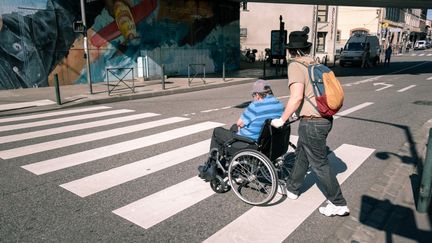 Un aide à domicile accompagnant une personne handicapée, à Toulouse, le 29 avril 2020. (ADRIEN NOWAK / HANS LUCAS / AFP)