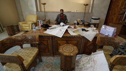 Un combattant de l'opposition syrienne s'installe symboliquement derrière un bureau du palais présidentiel de Damas, à la suite de la chute du régime, le 8 décembre 2024. (OMAR SANADIKI / AP / SIPA)