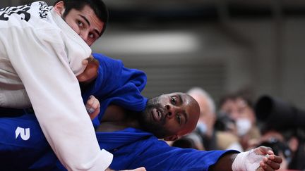 Teddy Riner est à terre. À la surprise générale, il s'incline en quart de finale des Jeux olympiques de Tokyo face au numéro 1 mondial des plus de 100 kilos, le Russe Tamerlan Bashaev, le 30 juillet 2021. Pas de troisième titre olympique en individuel pour le champion français. (FRANCK FIFE / AFP)