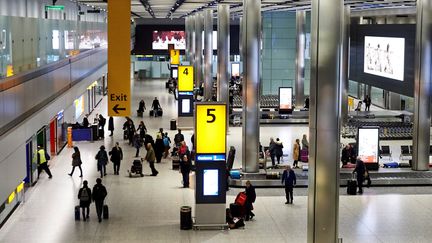 Des passagers récupèrent leurs bagages dans le terminal 5 de l'aéroport d'Heathrow, à Londres (Royaume-Uni), le 19 décembre 2018. (AFP)