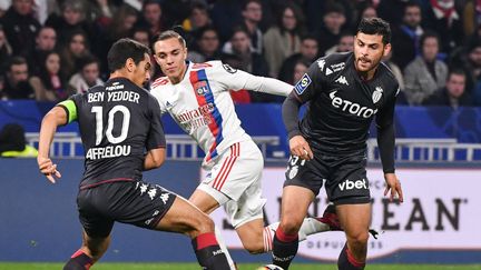 Le Lyonnais Maxence Caqueret cerné par les Monégasques Wissam Ben Yedder&nbsp;et Kevin Volland, le 16 octobre au Groupama Stadium.&nbsp; (PHILIPPE DESMAZES / AFP)