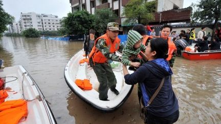 Les secouristes chinois évacuent les résidents d¿une rue inondée du district de Hechuan, Chongqing, 20 Septembre 2011 (PHOTO AFP / IMAGINECHINA)