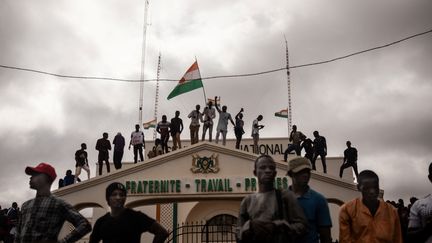 Des manifestants brandissent un drapeau nigérien, le 3 août 2023 à Niamey (Niger). (AFP)