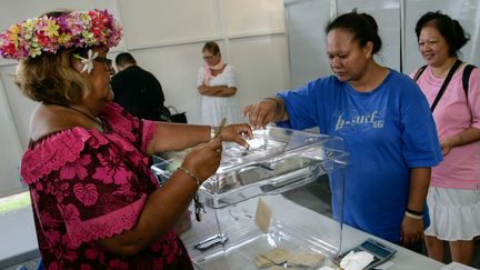 Une électrice glisse son bulletin de vote dans l'urne à Tahiti (Polynésie française), le 22 avril 2017. (GREGORY BOISSY / AFP)