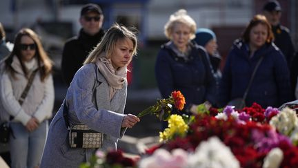 Des habitants se recueillent, le 27 mars 2024, devant le Crocus City Hall, la salle de concert près de Moscou (Russie) visée par une attaque terroriste. (ALEXANDER ZEMLIANICHENKO/AP/SIPA)