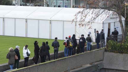 Des personnes attendent&nbsp;à l'entrée de l'hôpital Saint-Thomas pour être vaccinées contre le Covid-19, le 10 décembre 2021 à Londres (Royaume-Uni).&nbsp; (RAY TANG / ANADOLU AGENCY / AFP)