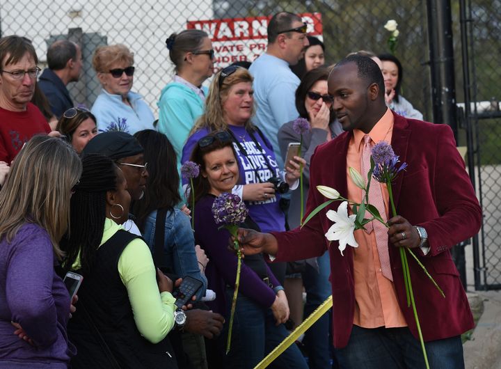 Des membres de son équipe sont sortis avec un grand vase de fleurs -  violet, la couleur fétiche du chanteur -, en offrant quelques-unes aux fans qui  les ont applaudis en signe de remerciement
 (Mark Ralston / AFP)