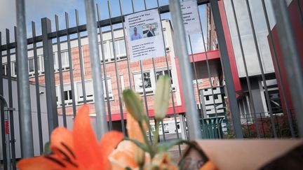 Des fleurs déposées devant l'école Pierre-Simon de Laplace, à Lisieux (Calvados), le 12 août 2023, après la mort de son principal. (LOU BENOIST / AFP)