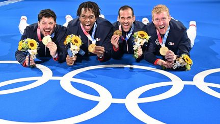 Maxime Pauty, Enzo Lefort, Erwann Le Pechoux et Julien Mertine savourent leur médialle d'or olympique à Tokyo, le 1er août 2021.&nbsp; (FABRICE COFFRINI / AFP)