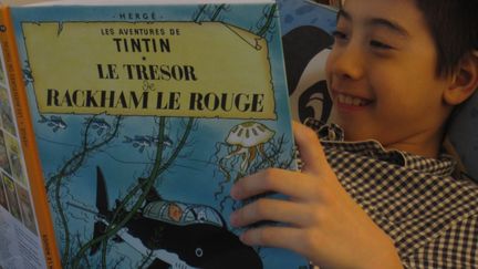 Valentin plongé dans son album de Tintin avant de dormir.
 (Deturgylone)