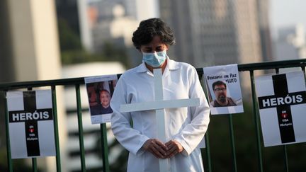 A Sao Paulo, des soignants comme cette infirmière ont profité du 1er-Mai pour rendre hommages à leurs collègues morts en "héros" des suites du Covid-19. (AMANDA PEROBELLI / REUTERS)