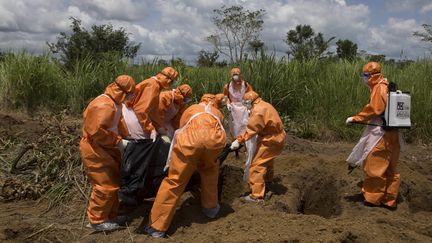 Des personnes en&nbsp;combinaisons de protection préparent l'enterrement d'une victime d'Ebola, le 27 septembre 2014 à Port Loko, en Sierra Leone. (Photo d'illustration) (REUTERS)