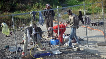 Des migrants se lavent sur un site en construction, pr&egrave;s d'un squat, &agrave; Calais (Pas-de-Calais), le 26 septembre 2008. (PHILIPPE HUGUEN / AFP)