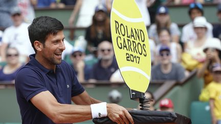 Novak Djokovic fait le pitre sur le court, en attendant le début du tournoi. (FRANCOIS-XAVIER MARIT / AFP)