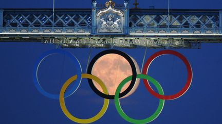 Pleine lune sur Londres, elle s'aper&ccedil;oit &agrave; travers les anneaux olympiques qui d&eacute;corent&nbsp;Tower Bridge durant les JO.&nbsp; (LUKE MACGREGOR / REUTERS)