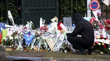 Un homme dépose des fleurs devant la propriété de Johnny Hallyday, à Marnes-la-Coquette (Hauts-de-Seine), après la mort du chanteur, le 7 décembre 2017. (MAXPPP)