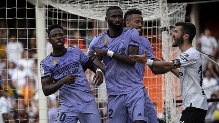 Le Brésilien Vinicius soutenu par ses coéquipiers Antonio Rudiger et Eder Militao, après avoir subi des insultes racistes lors du match Valence-Real Madrid, le 21 mai 2023. (JOSE MIGUEL FERNANDEZ / AFP)