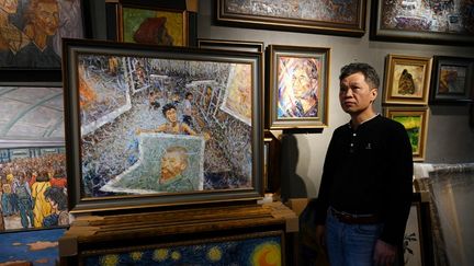 Le peintre Zhao Xiaoyong pose dans son atelier de Dafen, Chine. (GREG BAKER / AFP)