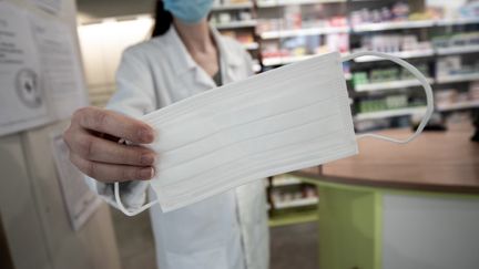 Une pharmacienne tend un masque à Périgueux. Illustration. (ROMAIN LONGIERAS / HANS LUCAS)