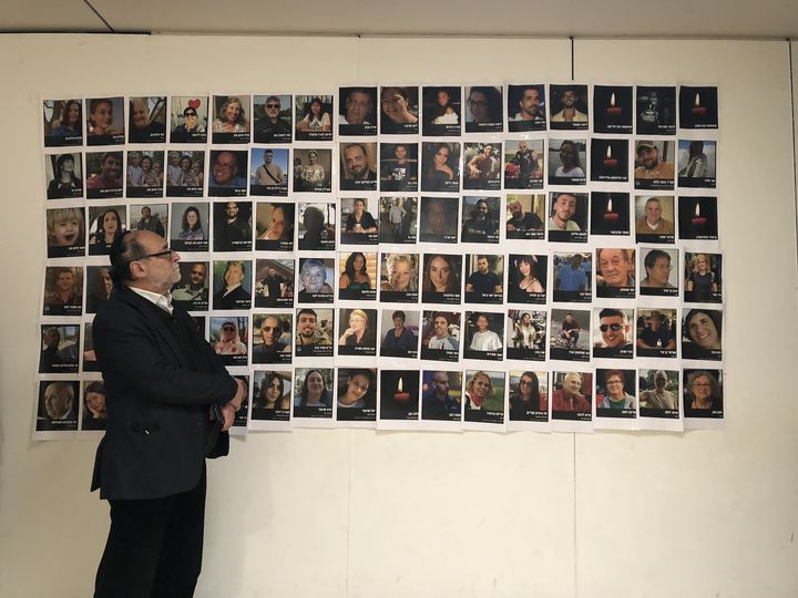 Albert Myara, responsable de la communauté juive du Kremlin-Bicêtre (Val-de-Marne), le 8 novembre 2023, devant les photos de victimes de l'attaque du Hamas en Israël. (RAPHAEL GODET / FRANCEINFO)