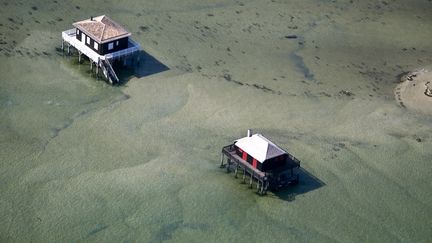 La cabane tchanquée numéro 3 (à droite) située dans le bassin d'Arcachon (Gironde) fait partie des monuments sélectionnées pour l'édition 2023 du loto du patrimoine. (PHILIPPE ROY / AURIMAGES VIA AFP)