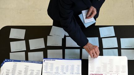 Une personne devant des bulletins de vote lors du second tour des élections régionales en&nbsp;Alsace-Champagne-Ardenne-Lorraine, le 13 décembre 2015. (MAXPPP)