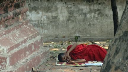 En pleine chaleur, comme ici dans la pagode Kyauktawgyi, bel édifice en bois construit en 1847 à côté de Mandalay, même plus jeune, un moine se laisse parfois aller à se reposer…
 (France Télévisions)