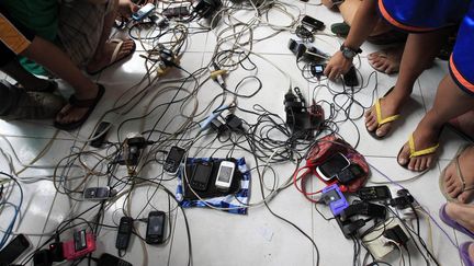 Des personnes chargent leurs t&eacute;l&eacute;phones apr&egrave;s le passage du typhon Rallassun, &agrave; &agrave; Rosario (Philippine), le 18 juillet 2014. (ROMEO RANOCO / REUTERS)