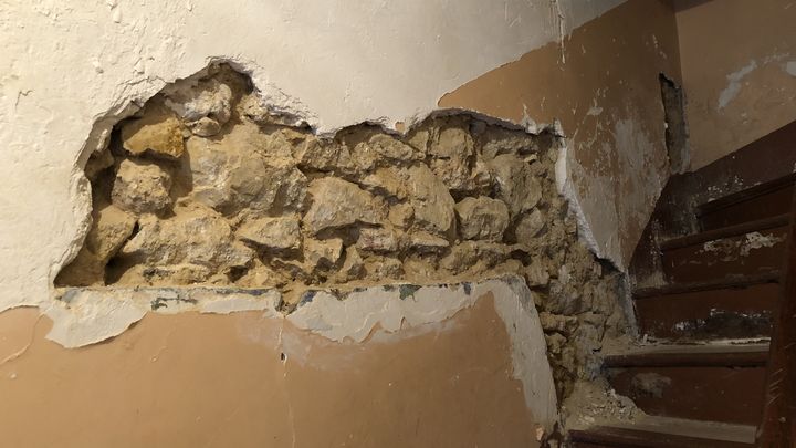 Au 40 rue du Bruys, dans le centre-ville de Marseille, le mur du hall d'entrée s'effondre sur l'escalier. (MATHILDE GOUPIL / FRANCEINFO)