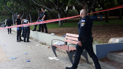 La police israélienne sur la scène d'une attaque au couteau survenue en pleine rue, à Holon, dans la banlieue sud de Tel Aviv, le 4 août 2024. (GIL COHEN-MAGEN / AFP)