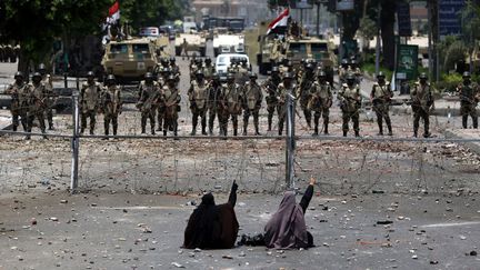 Des supportrices du pr&eacute;sident d&eacute;chu Mohamed Morsi d&eacute;fient la garde r&eacute;publicaine devant leur quartier g&eacute;n&eacute;ral au Caire (Egypte), le 8 juillet 2013. (MAHMUD HAMS / AFP)