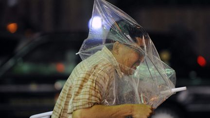 Un homme se bat avec son parapluie alors qu'une violente temp&ecirc;te due au typhon Guchol menace Tokyo (Japon), le 19 juin 2012. (EPA / MAXPPP)