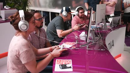 Au "Gamescom" de Cologne (Allemagne), des visiteurs jouent avec le cloud gaming "Doom" dans le stand de Google Stadia, le 21 août 2019.&nbsp; (INA FASSBENDER / AFP)