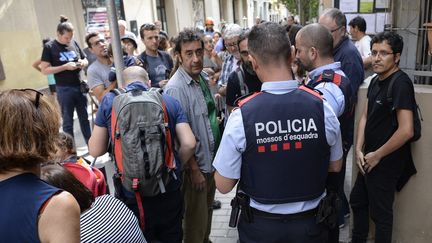 Des policiers catalans discutent avec des indépendantistes présents dans une école dans le quartier de barcelonais de Garcia (Espagne), le 30 septembre 2017. (JOSEP LAGO / AFP)