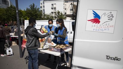 Des volontaires du Secours populaires distribuent de la nourriture à Saint-Denis (Seine-Saint-Denis), le 6 mai 2020. (THOMAS SAMSON / AFP)