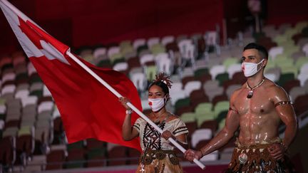 Les deux porte-drapeaux des îles Tonga,&nbsp;Malia Paseka&nbsp;et Pita Taufatofua, torse-nu,&nbsp;ont marqué les esprits pendant le défilé des délégations olympiques. La parade avait commencé par la Grèce, pays des origines des Jeux olympiques, avant le passage de nations comme les Etats-Unis, la France et le Japon, pays organisateur. (HANNAH MCKAY / AFP)